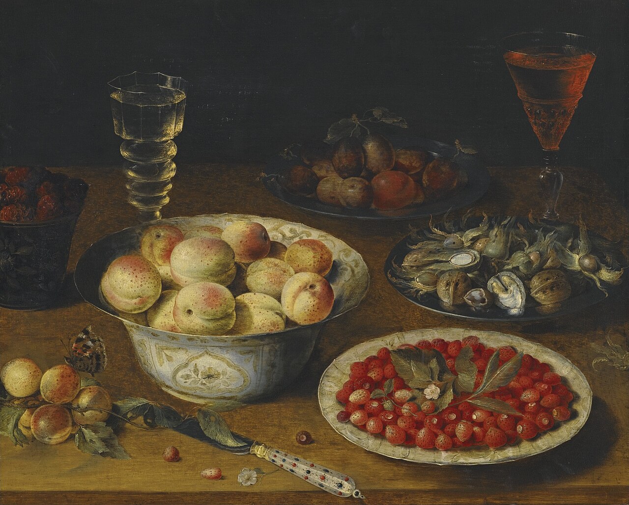 Fruit still life with two wine glasses on a wooden table by Osias Beert